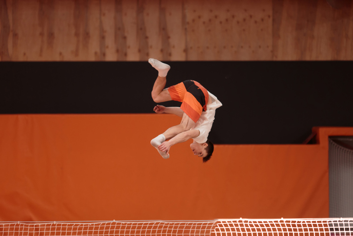 Young athlete on the trampoline in the graceful flight.