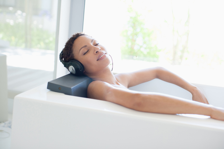 Woman listening to music in bathtub
